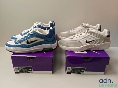 two pairs of nike air max sneakers are on a purple and white box