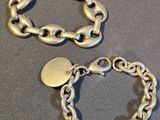 two pieces of silver bracelets on a table