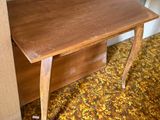 a small table with a wooden top in the corner of a room