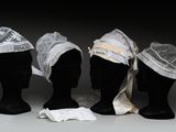 trois têtes de mannequins coiffées de chapeaux, exposées sur une table