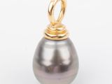 an image of a black pearl and gold pendant on a white background