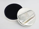 a silver box with a black lid on a white surface