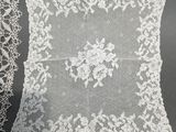 a close up of a white lace pillow on a table