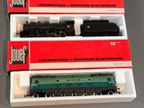 trois trains miniatures dans leurs boîtes, empilés les uns sur les autres