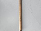 a close up of a wooden mallet on a white surface