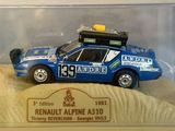 a blue toy car in a clear case on a table