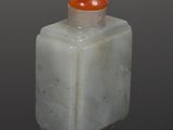 a picture of a white and orange stone bottle with a red top