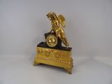 a gold clock with an angel on top of it
