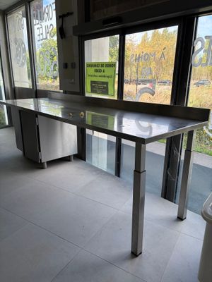 une table au milieu d'une pièce, avec une poubelle devant
