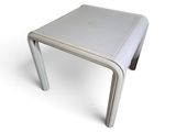 une petite table blanche surmontée d'un piètement métallique