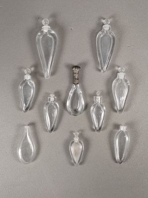 six clear glass bottles are arranged in a row on a gray surface