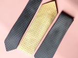 three ties on a pink background with a yellow and black checkered pattern