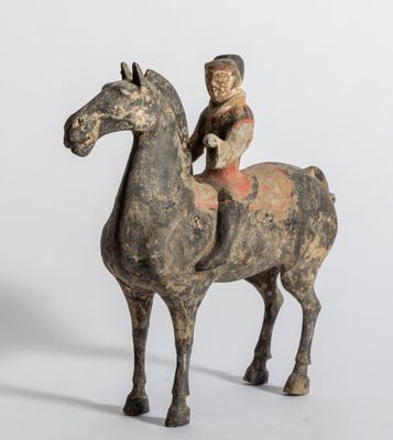 une vieille figurine représentant un homme à cheval avec un enfant sur le dos
