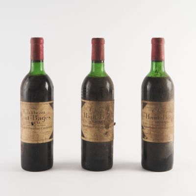 trois bouteilles de vin posées les unes à côté des autres sur une surface blanche