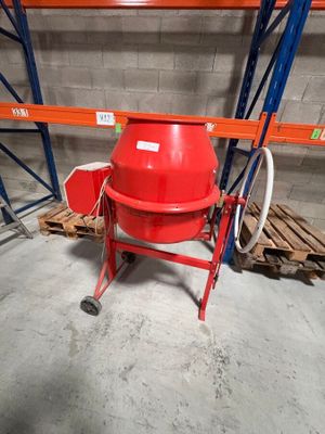 une bétonnière rouge dans un entrepôt rempli de palettes sur des palettes