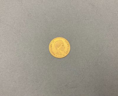 une pièce d'or posée sur une surface grise