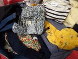 a suitcase full of clothes and a backpack on the floor