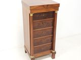 an image of a wooden chest of drawers against a white wall