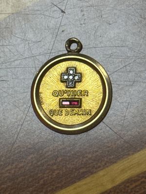 a gold medal with a cross on it sitting on a table