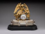 une horloge en or surmontée d'un ange