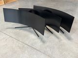 three curved black computer monitors sitting on top of each other