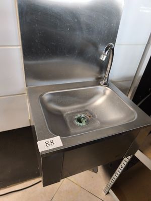 un évier en acier inoxydable dans le coin d'une salle de bains