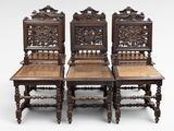 three antique carved chairs with cane seats and cane backs