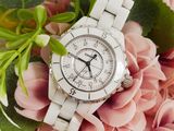 a close up of a white watch on a pink flower