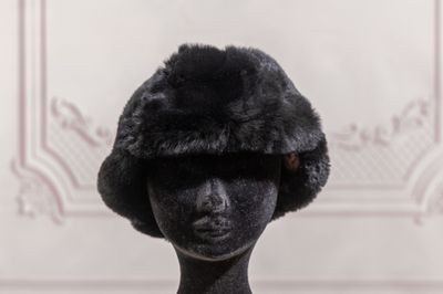 a black mannequin head with a fur hat on it
