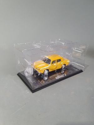 a yellow toy truck in a clear box on a table