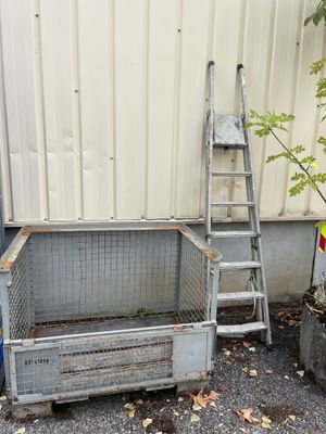 a metal crate with a ladder next to it