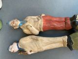 two figurines of a man and a woman laying on a table