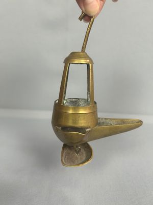 quelqu'un tient un petit objet métallique dans lequel se trouve un verre