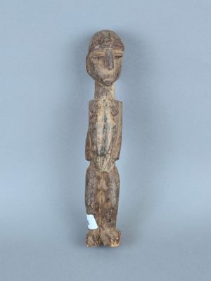 une vieille statue en bois d'un homme avec un chapeau sur la tête
