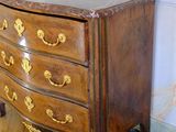 a wooden chest of drawers with gold decorations on it