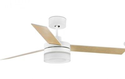 Le ventilateur de plafond est blanc et ses pales sont en bois.