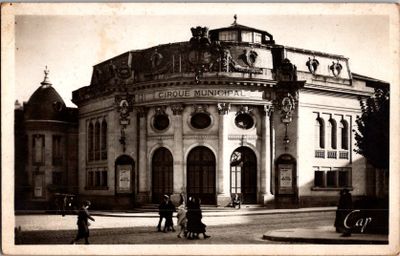 une vieille photo d'un bâtiment autour duquel des gens se promènent