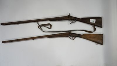 three old guns are displayed on a wall in a room