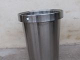 a metal trash can sitting in front of a wall
