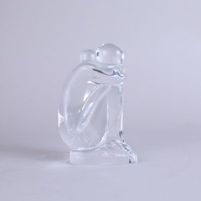 a glass figurine of a frog sitting on a base
