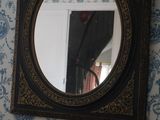 un miroir accroché au mur au-dessus d'une chaise dans une pièce
