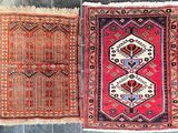deux tapis orientaux exposés sur un sol carrelé dans une pièce