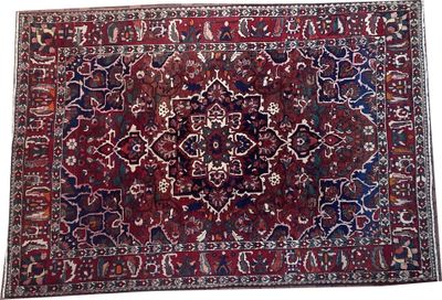 un tapis rouge et bleu orné d'un motif en médaillon sur fond blanc