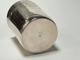 a silver cup that is sitting on a white surface