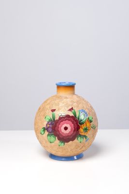 un petit vase sur lequel est peinte une fleur