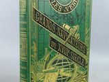 un vieux livre à la couverture verte posé sur une table