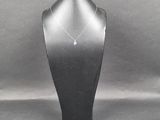 un collier sur un mannequin orné d'une pierre verte