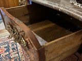 a wooden drawer with a marble top in a room