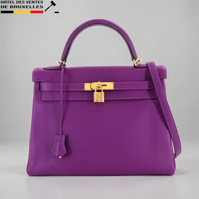 un sac à main violet muni d'un fermoir doré sur la poignée