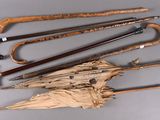 many different types of umbrellas and canes on the table